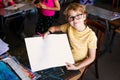 Blonde boy with glasses drawing. Group of elementary school pupils in classroom on art class. Paper with white free space for text