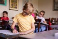 Blonde boy with glasses drawing. Group of elementary school pupils in classroom on art class. Russia, Krasnodar, May, 23, 2019