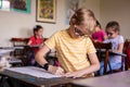 Blonde boy with glasses drawing. Group of elementary school pupils in classroom on art class. Russia, Krasnodar, May, 23, 2019