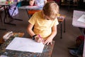 Blonde boy with glasses drawing. Group of elementary school pupils in classroom on art class. Russia, Krasnodar, May, 23, 2019