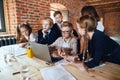 Blonde boy in glasses and his friends sitting in front laptop Royalty Free Stock Photo