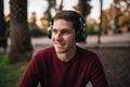 Blonde boy listening to music on wireless headphones sitting on the floor without looking at the camera. Enjoying the song. Royalty Free Stock Photo