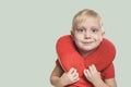 Blonde boy in a red T-shirt with travel pillow Royalty Free Stock Photo