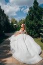 a blonde bride running down a path in the park in a white long dress. Royalty Free Stock Photo