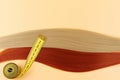 Blonde and brown-haired curls and a yellow measuring tape