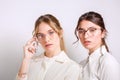 Two young pretty ladies isolated wearing reading glasses Royalty Free Stock Photo