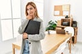 Blonde business woman at the office looking confident at the camera smiling with crossed arms and hand raised on chin Royalty Free Stock Photo