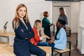 Blonde business woman smiles at camera with colleagues working in background Royalty Free Stock Photo