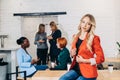 Blonde business woman smiling at camera with colleagues working in background Royalty Free Stock Photo