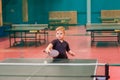 Blonde Caucasian boy playing table tennis in a specialized room Royalty Free Stock Photo