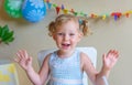 Blonde, Caucasian girl smartly dressed and smiling while looking at the camera. The concept of a birthday and making wishes