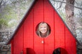 Blonde caucasian woman peaking through a small window. Royalty Free Stock Photo