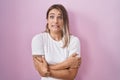 Blonde caucasian woman standing over pink background shaking and freezing for winter cold with sad and shock expression on face Royalty Free Stock Photo