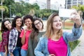 Blonde caucasian woman taking selfie with group of international Royalty Free Stock Photo