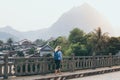 Blonde Caucasian woman walking on the bridge at sunset in Nong Khiaw, Laos Royalty Free Stock Photo