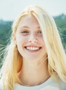 Blonde cheerful smiling girl close up portrait. International student traveling all around the world. Young woman