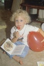 A blonde child eating a lollipop at a daycare center, Washington D.C.