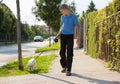 Young blonde boy walks along the street at summer time, with a very young golden retriever puppy dog. Royalty Free Stock Photo