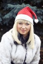 Blonde in Christmas cap and white furcoat Royalty Free Stock Photo