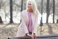 Blonde in coat at bench Royalty Free Stock Photo