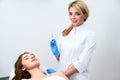Cosmetologist doctor standing near patient and holding botulinum syringe wearing gloves before operation, injections
