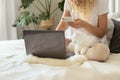 The girl is sitting on the bed with a laptop and makes online purchases Royalty Free Stock Photo