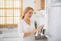 Blonde cute housewife cleaning and drying the plates