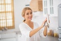 Blonde cute housewife holding a plate in her hands