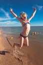 Blonde cute seven-year-old girl having fun and having a good time at the sea during the holidays Royalty Free Stock Photo