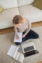 Blonde doing homework and sitting on floor using laptop Royalty Free Stock Photo