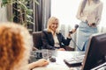 Blonde executive businesswoman doing multitasking work in office. Royalty Free Stock Photo