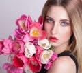 Blonde face, blue eyes, tulips flowers