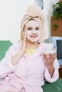 Blonde with face pack relaxing on sofa indoors Royalty Free Stock Photo