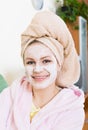 Blonde with face pack relaxing on sofa indoors Royalty Free Stock Photo