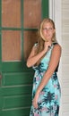 Blonde fashion model poses near shuttered house Royalty Free Stock Photo