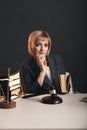 Blonde female advocate at the workplace isolated in studio reading book. Royalty Free Stock Photo