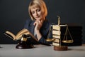 Blonde female advocate at the workplace isolated in studio reading book. Royalty Free Stock Photo