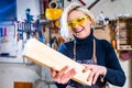 blonde female carpenter using tools for her work in a woodshop Royalty Free Stock Photo
