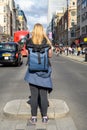 Blonde female photographer photographing a busy London Street