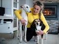 Blonde female playing with her two dogs, beagle and greyhound at home Royalty Free Stock Photo