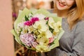 Blonde female smiles and holds a bouquet with orchids, roses and hydrangea Royalty Free Stock Photo