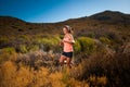 Blonde female trail runner running through a mountain landscape Royalty Free Stock Photo