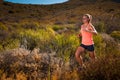 Blonde female trail runner running through a mountain landscape Royalty Free Stock Photo