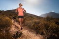 Blonde female trail runner running through a mountain landscape Royalty Free Stock Photo