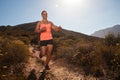 Blonde female trail runner running through a mountain landscape Royalty Free Stock Photo