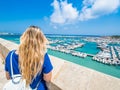 Blonde girl admires the harbour of Otranto, Apulia, Italy.