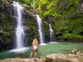 Blonde girl admires Three Bears Falls in Maui Hawaii Hana Highway, Waikani Falls