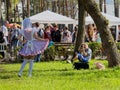 Blonde girl in anime character clothes sit for a photographer in a park at the festival of Japanese animation