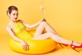 Blonde girl in a bathing suit and with a cocktail in her hands sits on an inflatable circle Royalty Free Stock Photo