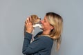 Blonde girl with Beagle puppy on gray background